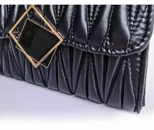 Dettaglio della borsa in pelle matelassé nera con fibbia geometrica dorata raffinata