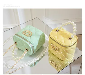 Detail of mini jelly bags in green and yellow with pearl handles and heart logo hardware