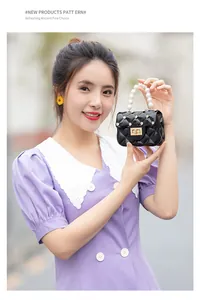 Détail du mini sac matelassé noir avec poignée en perles et fermoir rotatif doré