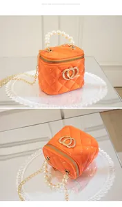 Detail of bright orange quilted jelly mini bag with pearl handle and golden heart logo