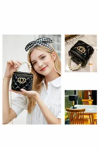 Dettaglio mini borsa trapuntata nera con manico di perle e chiusura a doppio cuore oro