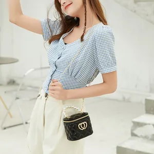 Mini black jelly bag with pearl handle, quilted pattern and golden double heart buckle