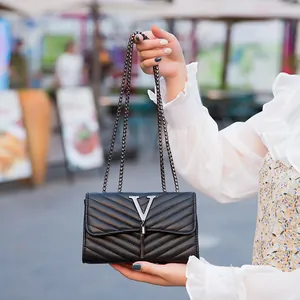 Borsa a tracolla trapuntata nera con logo V in metallo e nappa su sfondo stradale