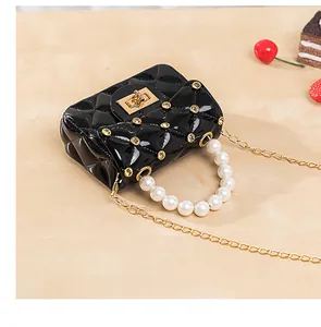 Détail d'un mini sac matelassé avec poignée en perles et ornements en strass brillants