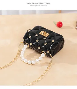 Détail du mini sac gelée noir matelassé avec poignée en perles et chaîne dorée