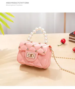 Détail du mini sac jelly rose avec matelassage diamant, poignée perle et chaîne dorée