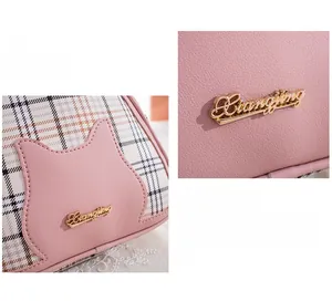 Detail showing pink lychee leather texture and contrast plaid fabric with cat logo