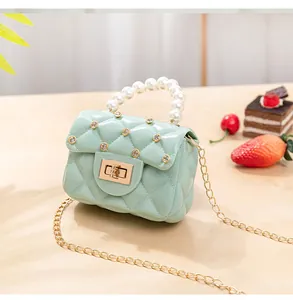 Gros plan du sac gelée vert menthe avec poignée en perles et détails strass