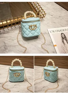 Dettaglio della mini borsa trapuntata celeste con logo a doppio cuore e manico di perle