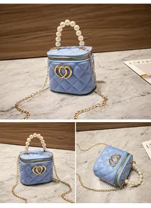 Dettagli della mini borsa trapuntata azzurra con manico di perle e chiusura a cuore oro