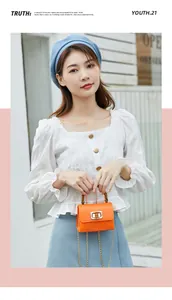 Mini borsa arancione effetto coccodrillo con manico in bambù e camicia bianca a sbuffo