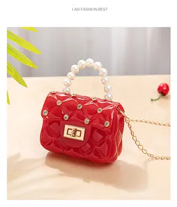 Détail du mini sac gelée rouge avec poignée en perles, strass et chaîne dorée chic