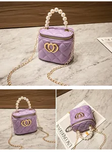 Dettaglio mini borsa trapuntata lavanda con manico di perle e fibbia a cuore dorata