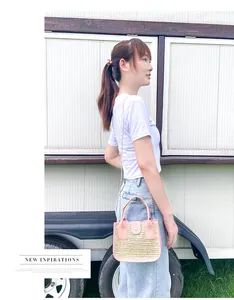 Détails de la bordure en cuir rose et paille tressée du sac avec chaîne dorée