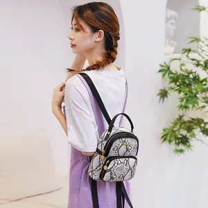 Mini fashion backpack with stylish black and white snake print and gold zipper charm