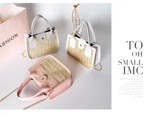 Vue détaillée de sacs à main en paille tressée rose et blanc avec bandoulière chaîne dorée