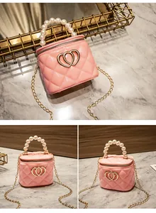 Dettaglio mini borsa vanity rosa trapuntata con manico di perle e catena d'oro
