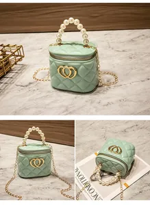 Dettaglio della mini borsa trapuntata verde menta con manico di perle e fibbia a cuore