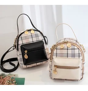 Detail of checkered mini backpack showing gold zippers and adjustable shoulder straps
