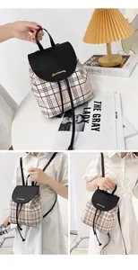 Detalle de mini mochila de cuadros con solapa de cuero negro y cierre de logotipo dorado
