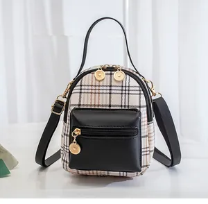 Detail shot of the checkered backpack showing the black leather pocket and golden zippers