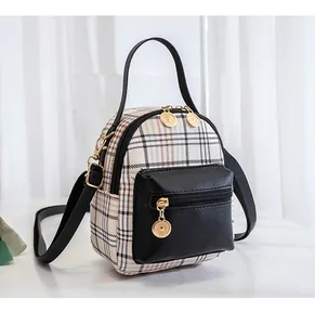 Detail of checkered plaid mini backpack with golden circular zipper charms and dual pockets