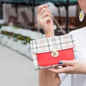 Women's chic plaid crossbody bag with red textured leather and gold chain strap