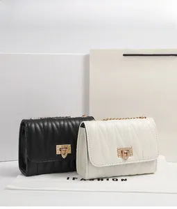 Detailed shot of quilted flap shoulder bags in black and white with gold chain straps