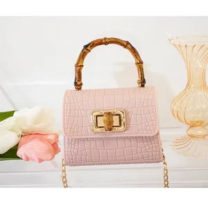 Dettaglio mini borsa rosa stampa coccodrillo con manico in bambù e chiusura dorata
