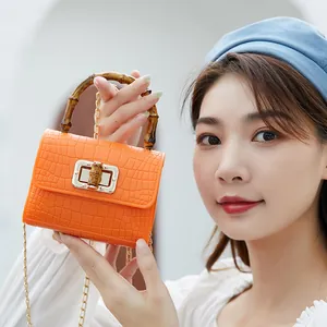Mini borsa arancione motivo coccodrillo con manico in bambù e catena dorata