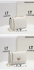 Close-up of white quilted PU leather bag with gold chain strap and metal heart lock