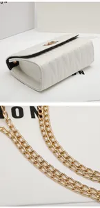 Detail of white quilted flap bag with gold metal chain strap and V-shaped stitching