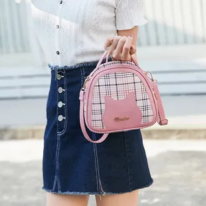 Pink checkered crossbody bag with cute cat silhouette and metal logo on a model