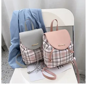 Primer plano de mochilas de cuadros azules y rosas con solapa de cuero y cordón ajustable