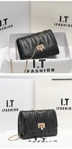 Detail of black quilted shoulder bag with gold chain strap and metallic lock closure