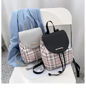 Detalle de mini mochilas de cuadros con solapa de PU y logo sobre una silla blanca