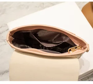 Detail view of pink crossbody bag interior with heart-shaped gold zipper and dark lining