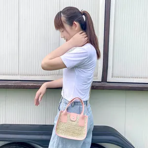 Sac bandoulière tissé pour femme avec garniture rose et chaîne dorée en extérieur