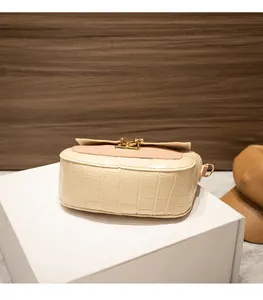 Detail of crocodile embossed faux leather handbag with pink flap and golden metal clasp