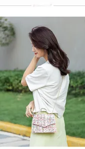 Outdoor model shot of small crossbody bag in colorful tweed fabric with golden chain strap