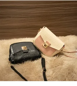 Detail of crocodile pattern leather bags with golden metal locks on a plush rug