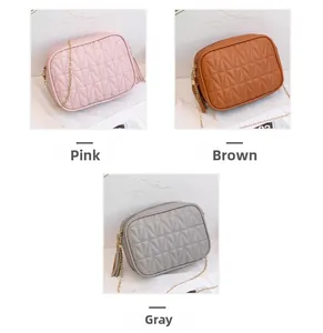 Detail of three chain square bags in pink, brown and grey with V-shaped quilted texture