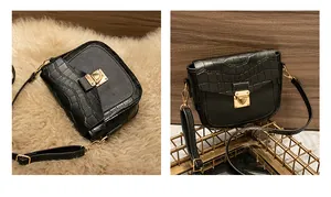 Detail of crocodile pattern leather flap and golden metal lock on a black crossbody bag