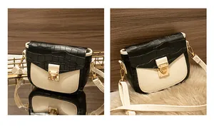 Detail view of crocodile pattern flap and golden metal lock on saddle shoulder bag