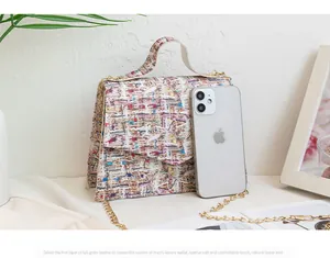 Macro shot of colorful tweed crossbody bag showing scale with a smartphone