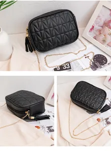 Close-up of black quilted PU leather crossbody bag with gold chain and fringe detail