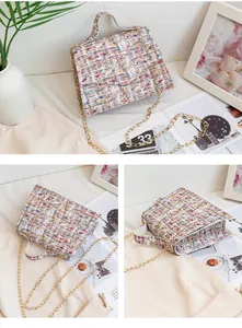 Close-up of small printed chain bag with colorful tweed texture and golden strap