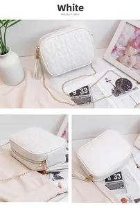 Macro detail of white quilted crossbody bag with golden chain and tassel zipper pull