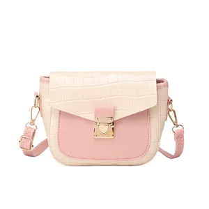 Pink and white crocodile pattern crossbody bag with gold lock on a white background