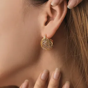 Elegant 18K gold brass hollow spherical bird nest earrings worn by a model in close-up